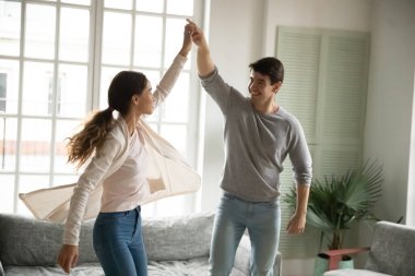 Oturma odasında dans eden mutlu beyaz çift