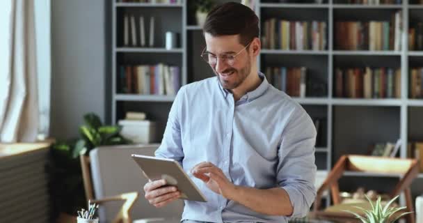 Χαμογελώντας αυτοπεποίθηση νέος επιχειρηματίας που διαχειρίζεται τις εργασίες εργασίας στο tablet. — Αρχείο Βίντεο