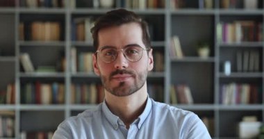 Kameraya bakan genç, mutlu, gözlüklü, yakışıklı bir adam..