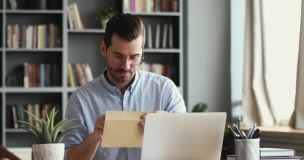 Curioso sorrindo jovem leitura carta com boas notícias . — Vídeo de Stock