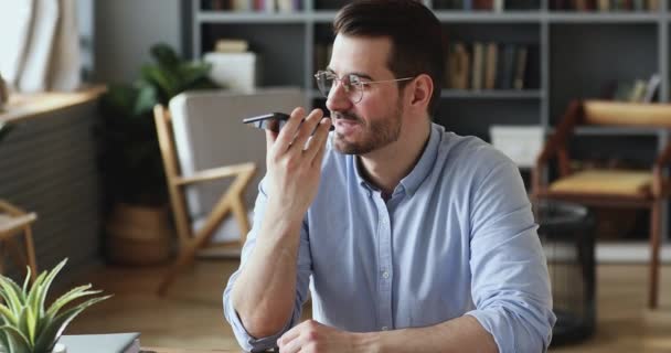 Empresário bonito feliz ditando mensagem de áudio no smartphone . — Vídeo de Stock