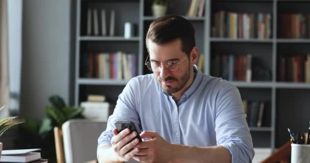 Захоплений молодий бізнесмен читає повідомлення з добрими новинами на смартфоні . — стокове відео