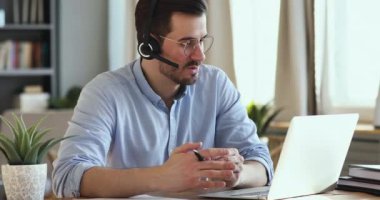 Focused businessman in eyeglasses holding video conference call with clients.