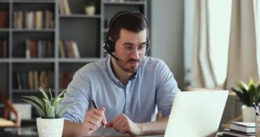 Confident young handsome businessman holding video call with clients.