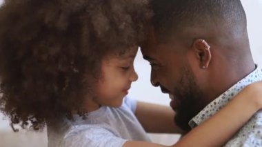 Loving african father and cute kid daughter touching noses bonding