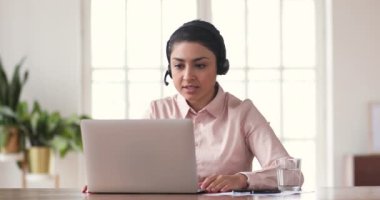 Focused young indian ethnicity company employee holding video call meeting.
