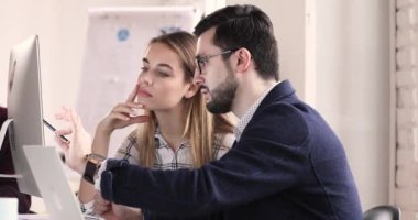 Skilled male coach educating young female intern in office.