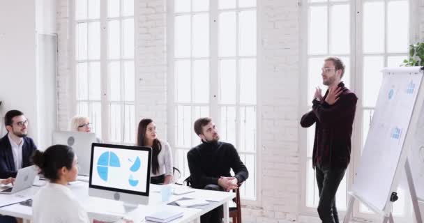 Focused diverse colleagues listening to young motivated skilled presenter. — Stockvideo