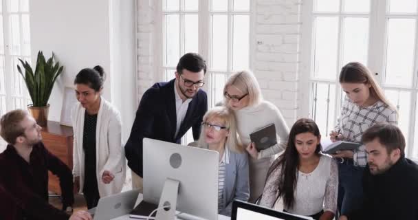 Focado inteligente diversos colegas que trabalham em pequenos grupos em computadores . — Vídeo de Stock