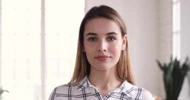Happy young attractive blonde woman looking at camera.
