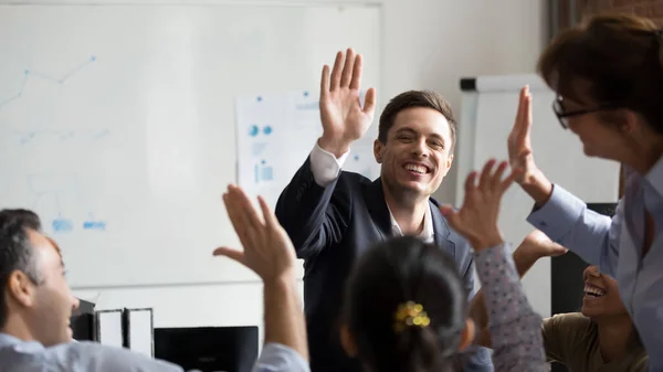 Happy diverse employees giving high five at company briefing — Zdjęcie stockowe