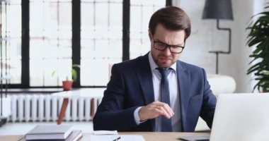 Unhappy 30s employee in formal suit suffering from runny nose.