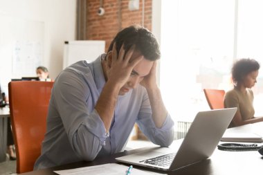 Unhappy businessman employee receive bad news, holding head in hands