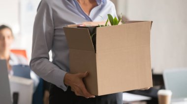 Close up businesswoman holding cardboard box with belongings