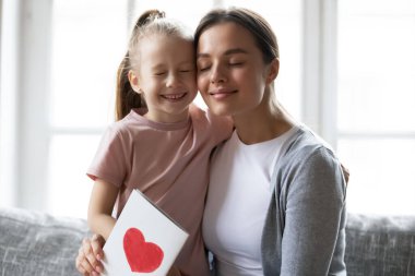 Happy mother hugging adorable daughter, thanking for congratulation