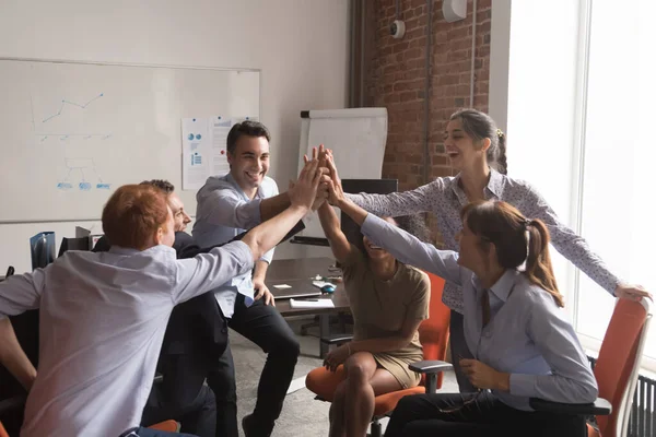 Excited laughing diverse employees giving high five at meeting — Stockfoto