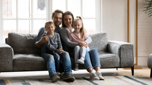 Family portrait little kids sitting on mother and father laps