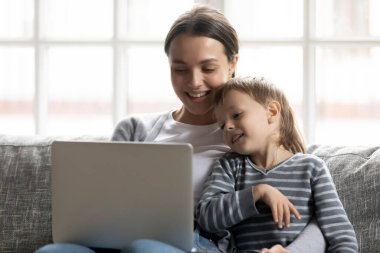 Happy young mother and little son using laptop together