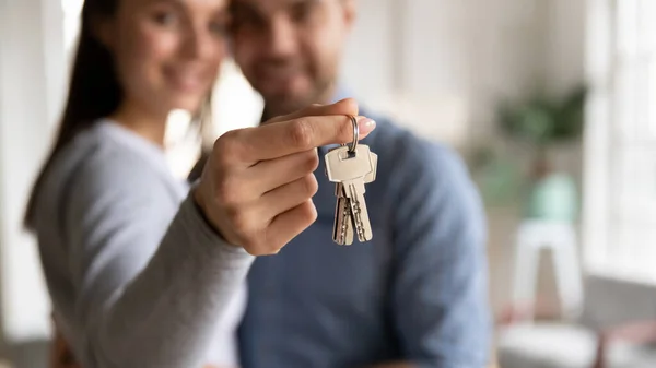 Close up happy young woman hugging man, holding keys — Stockfoto