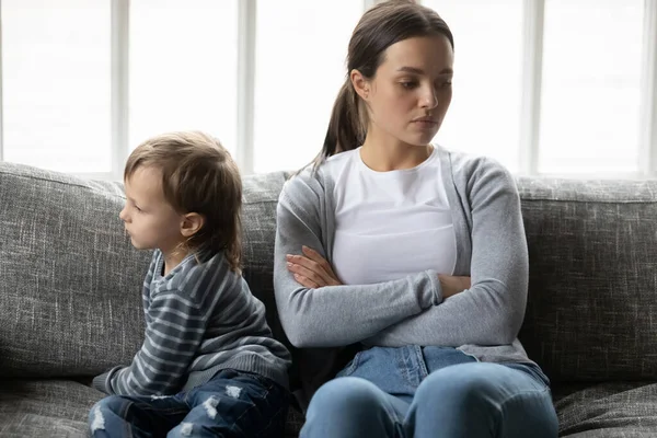 Розлючена молода мати і маленький син ігнорують один одного — стокове фото