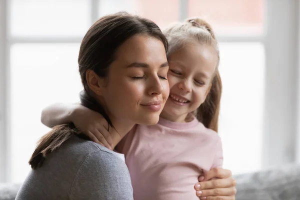 Närbild kärleksfull ung mor kramar bedårande liten dotter — Stockfoto