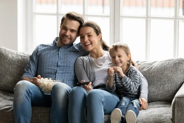 Joyeux jeunes parents avec petit fils regardant la télévision ensemble — Photo