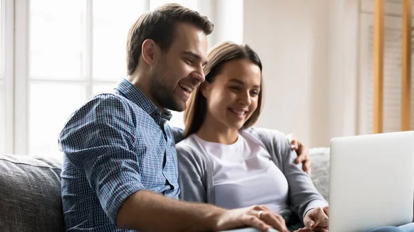 Feliz joven pareja divirtiéndose con el ordenador portátil juntos — Foto de Stock