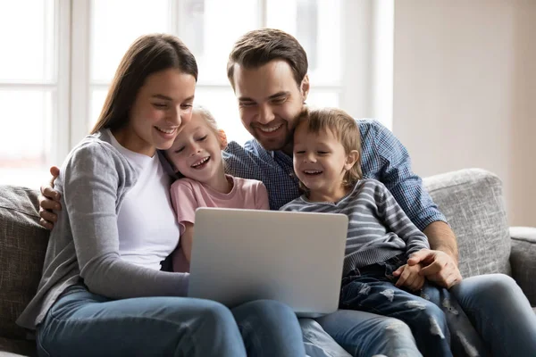 Happy family with son and daughter having fun with laptop — Stockfoto