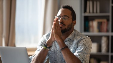 African closed eyes put palms together thinking search problem solution