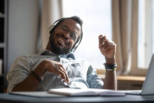 Homem africano usar fones de ouvido ouvir música desfrutar de pausa no local de trabalho — Fotografia de Stock