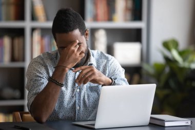African guy rubbing dry eyes takes off spectacles relieving eyestrain