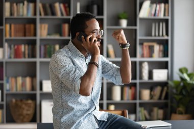 African man talking by cellphone received great news feels happy