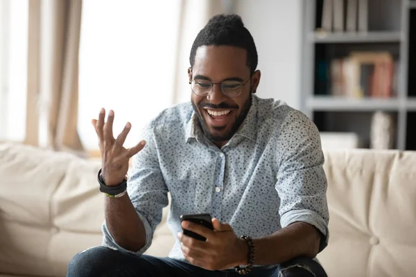 African man use smartphone read positive amazing news feels excited — Stockfoto