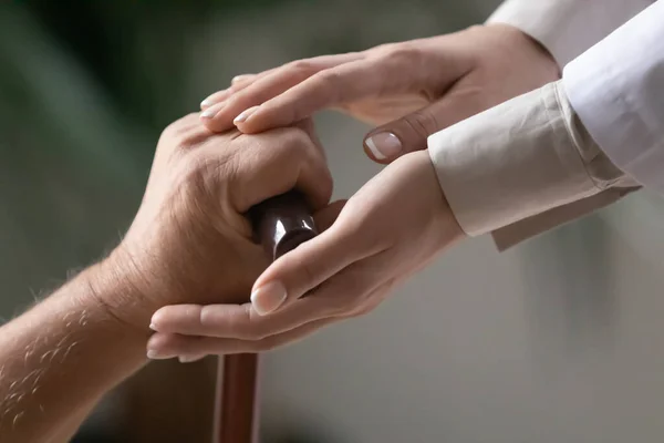 Close up female caregiver touching elderly disabled patient hand — Stock fotografie