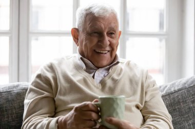Head shot happy smiling mature man holding cup of tea