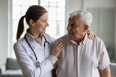 Head shot portrait smiling female doctor hugging older man