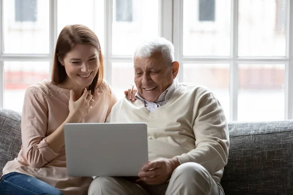 Feliz padre mayor y la hija adulta mirando la pantalla del ordenador portátil —  Fotos de Stock