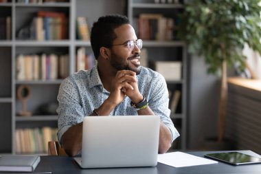 African male employee looking at window taking break from work