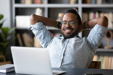African guy put hands behind head takes break watching movie