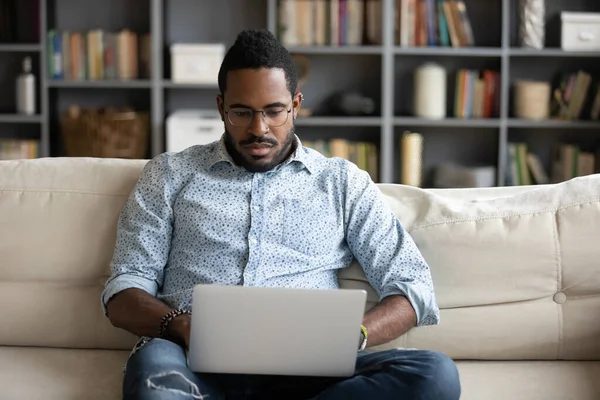 African man put notebook on lap do remote work — ストック写真