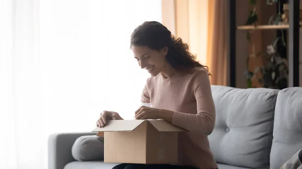 Sorrindo mulher unboxing pacote com ordem loja on-line, removendo o pacote — Fotografia de Stock