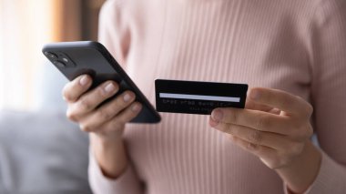 Çevrimiçi kredi kartıyla ödeme yapan kadını kapat, akıllı telefon kullanarak.