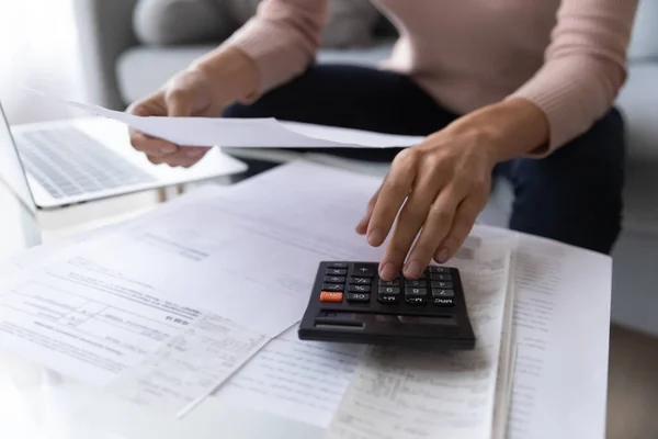 Mujer cercana usando calculadora, comprobando facturas domésticas — Foto de Stock