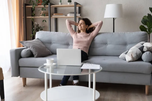 Souriant paisible jeune femme relaxant, appuyé sur le canapé — Photo