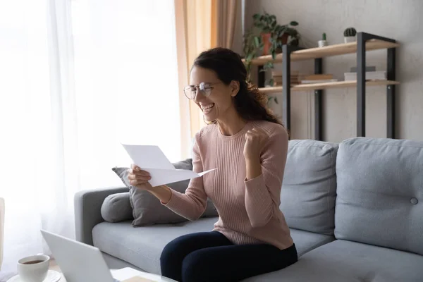 Excited woman wearing glasses reading letter with good news — ストック写真