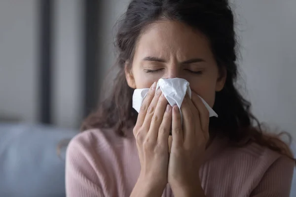 Крупним планом нездорова виснажена жінка дме носом, тримаючи тканину — стокове фото