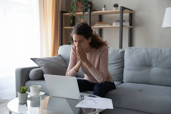 Расстроенная женщина смотрит на экран ноутбука, читает плохие новости — стоковое фото