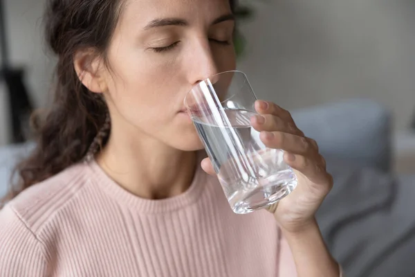 Закройте красивую молодую женщину, пьющую чистую минеральную воду — стоковое фото