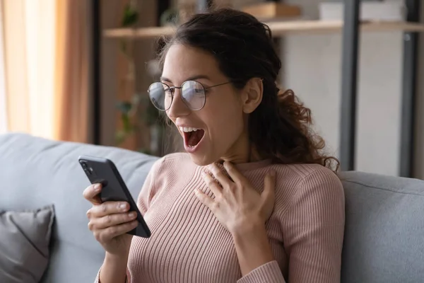 Mulher excitada lendo uma boa mensagem inesperada, olhando para a tela do telefone — Fotografia de Stock