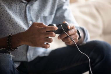 Closeup image african guy holding joypad playing playstation games